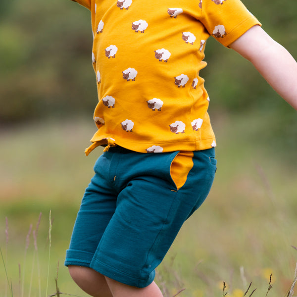 Boy wearing Little Green Radicals organic Green marl jogger shorts