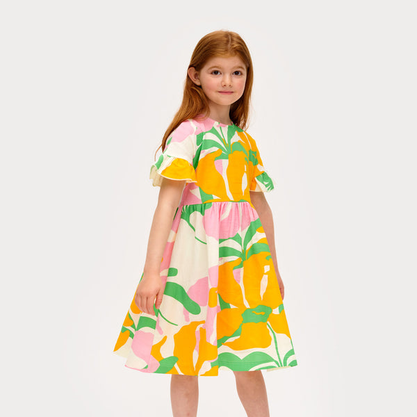 Girl wearing Mainio organic Muslin dress- lively floral