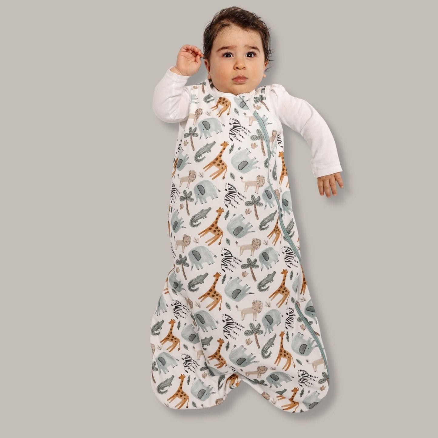 A baby sleep sack with safari animal prints, including giraffes and elephants, on a light background.