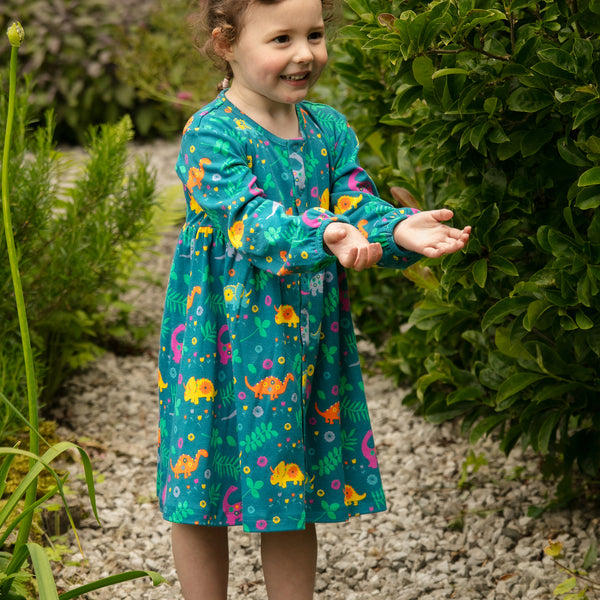 Girl wearing Piccalilly organic Long sleeve dress- dinosaur