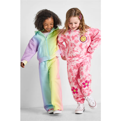 Two children wearing colorful tie-dye outfits on a white background