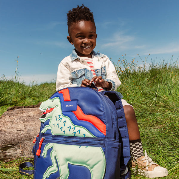 Boy carrying State Bags Kane backpack- dino