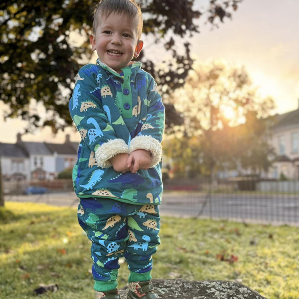 Boy wearing Toby Tiger organic Joggers- dinosaur print