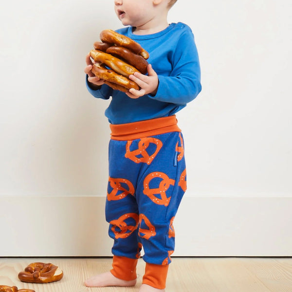 Bbay wearing Toby Tiger organic Print pants- pretzels