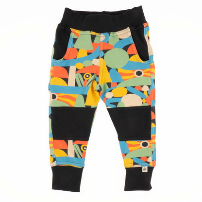 Colorful geometric-patterned pants with black accents on a white background