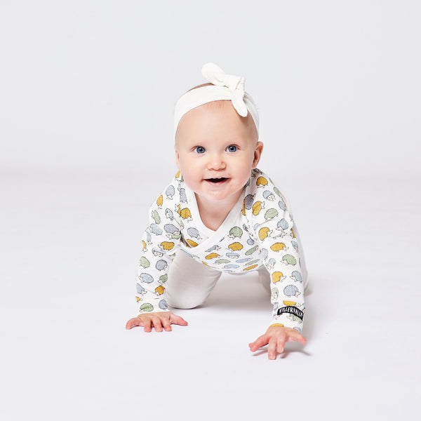 Baby wearing Villervalla organic Wrap-over bodysuit- hedgehog