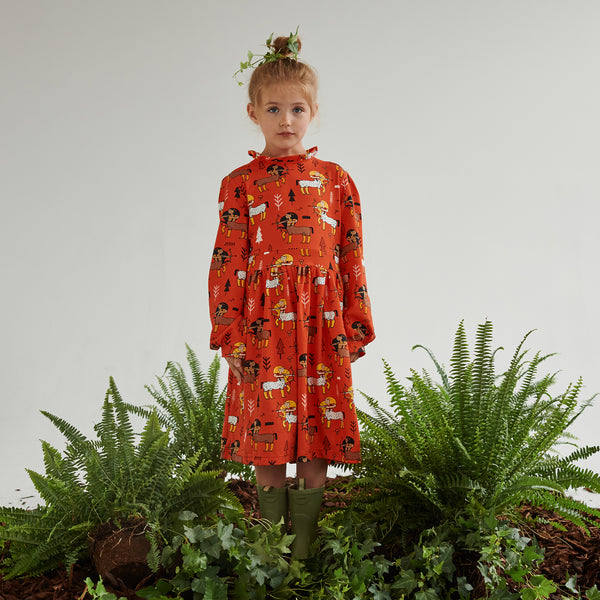Girl wearing Raspberry Republic organic Dress- tomato enchanted forest