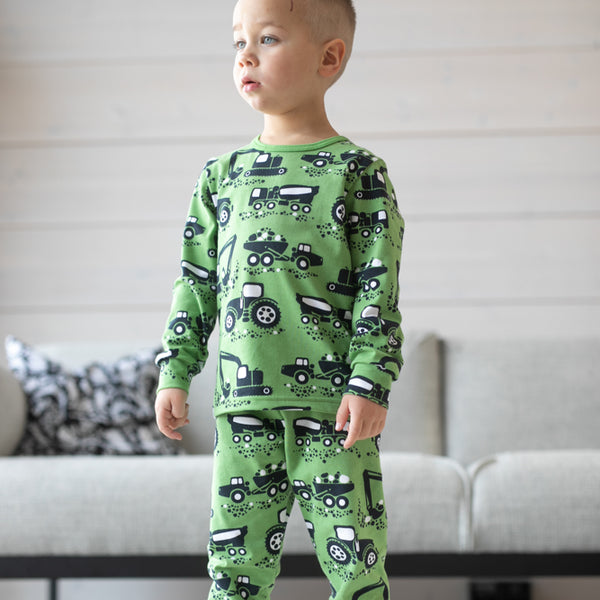 Boy wearing PaaPii Rusko pajamas- forest green machines