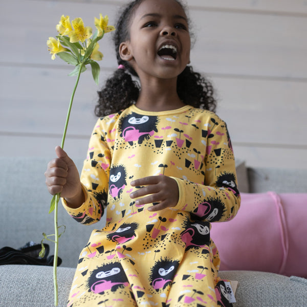 Girl wearing PaaPii Sinna skater dress- yellow & pink, Siiri in the garden