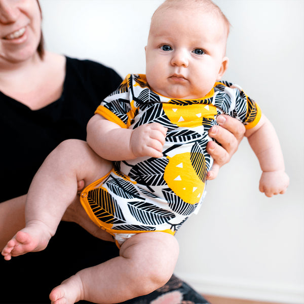 Baby wearing PaaPii short sleeve bodysuit- lemon sun