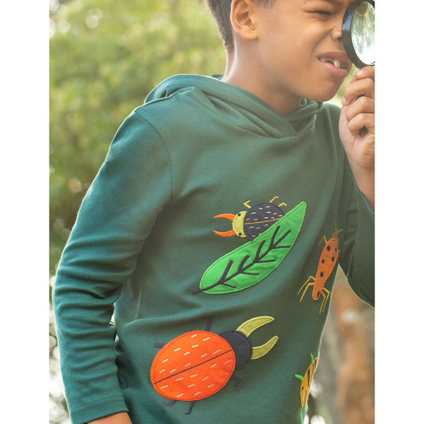Boy wearing Frugi organic Hooded top- fir tree/bugs