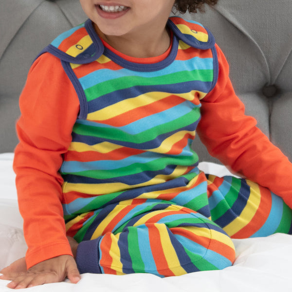Baby wearing Piccalilly Dungarees- rainbow stripe
