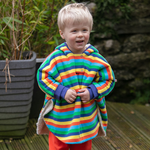 Boy wearing Piccalilly Poncho- rainbow stripe