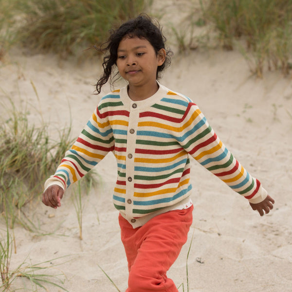 Girl wearing Little Green Radicals organic Rainbow striped knit cardigan