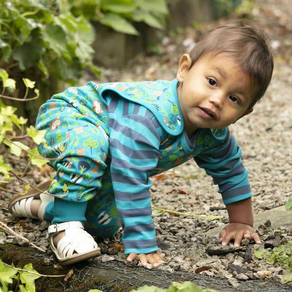 Baby wearing Piccalilly organic overalls- tree tops